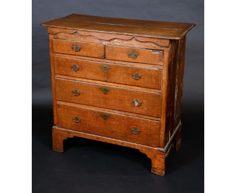 An unusual George II Provincial Gothic oak chest of drawers, idiosyncratic oversailing top above an ogee arched frieze and tw