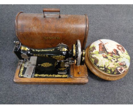 A vintage Singer hand sewing machine in oak case together with a tapestry upholstered foot stool