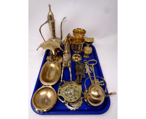 A tray containing a quantity of brass ware to include brass keys, horse brasses, soap dish, eastern style teapot, ashtray etc