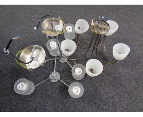 Two contemporary chrome three way light fittings with glass shades together with a further five way light fitting with glass 