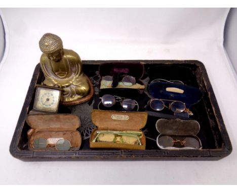 A quantity of antique and later spectacles, a small mantel clock, and a brass figure of Buddha on wooden plinth 