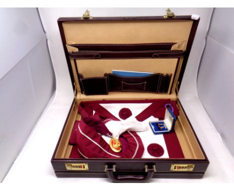 A leather briefcase containing Masonic regalia including sash, pair of cuff links etc