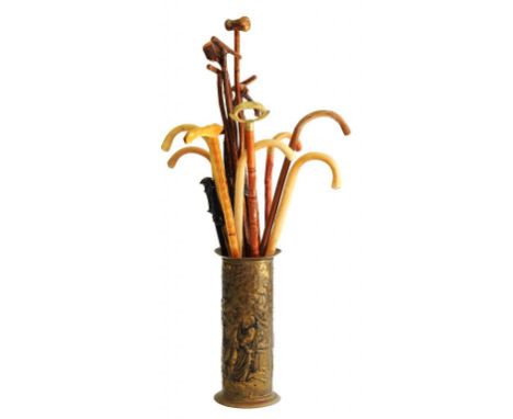 MISCELLANEOUS WOODEN WALKING STICKS AND CANES IN AN EMBOSSED BRASS STICK STAND