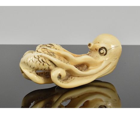 Netsuke. Oktopus hält einen Fisch in den Fängen. Elfenbein. Japan. Ende 19. Jh. L 5,5 cm.CITES vorhanden. Verkauf innerhalb d