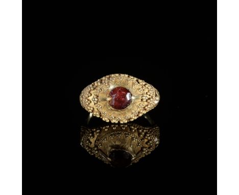 A GARNET-SET GOLD 'FLORAL' PRIEST'S RINGIndonesia, Bali, 19th to early 20th century. The gold ring with a conical bezel surmo