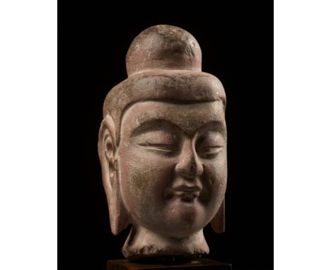 A SANDSTONE HEAD OF BUDDHA, NORTHERN WEI DYNASTYChina, 386-534. Well carved with a slightly elongated face rendered with a be