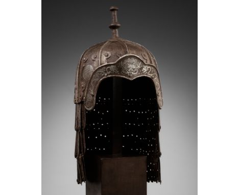 A SILVER-DAMASCENED 'DRAGON' IRON HELMET, 17TH-18TH CENTURYTibet. The exterior of the helmet made from nine curved plates, se