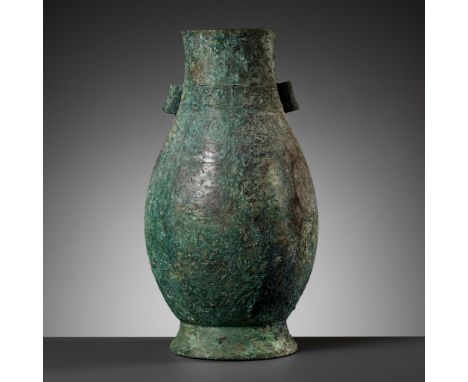 A RARE ARCHAIC BRONZE RITUAL WINE VESSEL, HU, MIDDLE WESTERN ZHOU DYNASTY 西周中期罕見青銅壺   Expert's note: This vessel comes in a 1