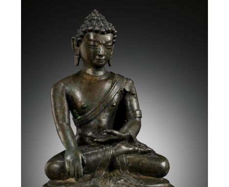 A BRONZE FIGURE OF BUDDHA, NEPAL, 14TH-15TH CENTURY 十四至十五世紀尼泊爾佛陀銅像Heavily cast seated in dhyanasana with the right hand lower