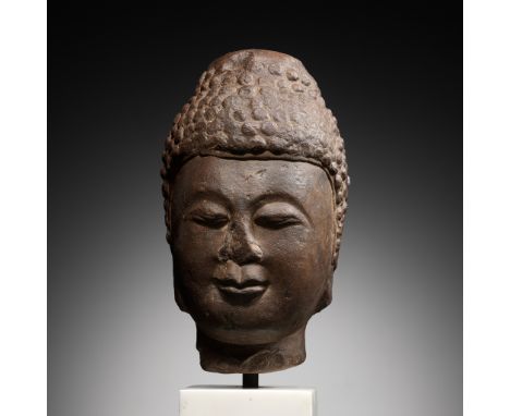 A LIMESTONE HEAD OF BUDDHA, TANG DYNASTY, CHINA, 7TH - EARLY 8TH CENTURY 唐代七至八世紀初石灰石佛頭Expert's note: The present monumental B