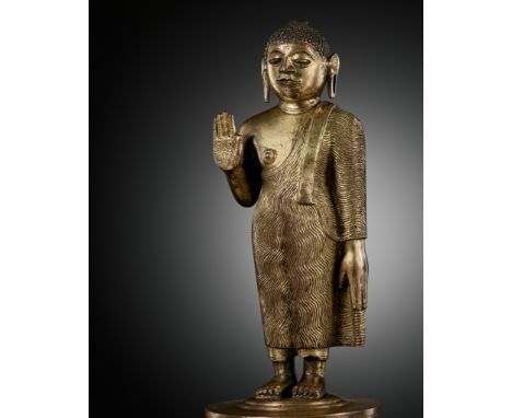 A GILT-BRONZE STANDING FIGURE OF BUDDHA SHAKYAMUNI, KANDYAN PERIODSri Lanka, 18th to early 19th century. Finely cast standing