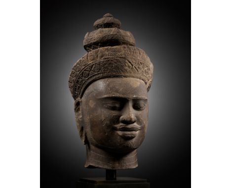A LARGE SANDSTONE HEAD OF VISHNU, ANGKOR PERIOD, PRE RUP STYLEKhmer Empire, 10th century. Sensitively carved, the serene face
