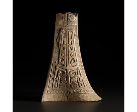 AN ARCHAIC CEREMONIAL BONE CARVING, SHANG DYNASTY 商代骨雕祭祀用器China, 14th-11th century BC. A thin fragment of a hip bone, likely 