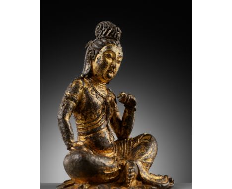 A GILT BRONZE FIGURE OF GUANYIN, PROBABLY TANG DYNASTYChina, 618-907 or later. The deity seated in rajalilasana, one hand res