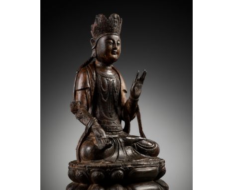 A LACQUERED WOOD FIGURE OF GUANYIN, MING DYNASTYChina, 15th century. Seated in dhyanasana on a beaded double lotus base, the 