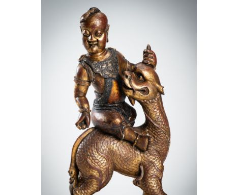 A VERY LARGE GILT-LACQUERED WOOD STATUE OF YOUNG BUDDHA RIDING QILINChina, Qing Dynasty (1644-1912). Depicting Buddha as a yo
