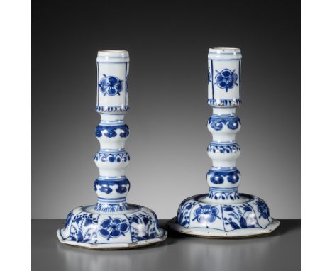 A PAIR OF BLUE AND WHITE CANDLESTICKS, KANGXI PERIODChina, 1662-1722. Each raised on a domed octagonal base decorated with pa