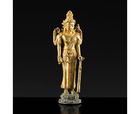 A RARE GILT COPPER ALLOY FIGURE OF VISHNU, JAVA, 14TH-15TH CENTURY OR EARLIERFinely cast standing in samapada atop a circular