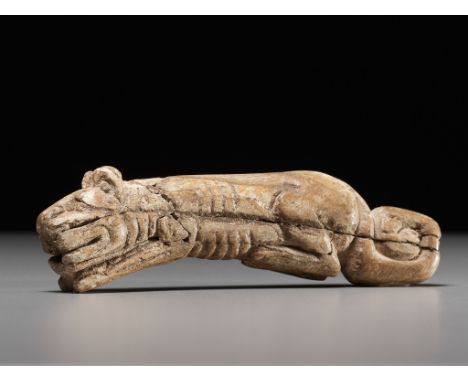 A RARE CARVED BONE FIGURE OF A TIGER, SHANG DYNASTY 商代罕見臥虎形骨觿China, 11th century BC. Well carved in the round as a crouching 