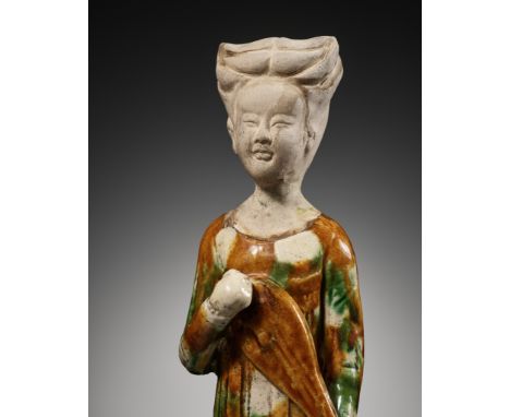 A SANCAI GLAZED POTTERY FIGURE OF A FEMALE MUSICIAN PLAYING THE PIPA, TANG DYNASTY 唐代三彩琵琶陶俑China, 618-907. Well modeled stand