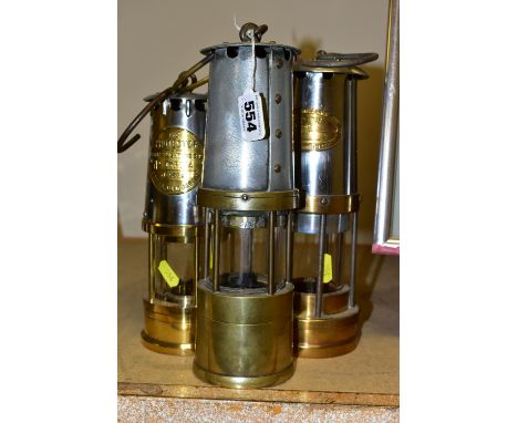 THREE BRASS AND IRON MINER'S LAMPS, The Protector Lamp &amp; Lighting Co. Ltd No. Type 1A lamp, a J.H Naylor ltd of wigan lam