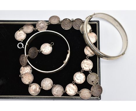 TWO BANGLES AND A COIN NECKLACE, to include a silver hinged bangle with scroll engraved detail and rope twist border, maker's