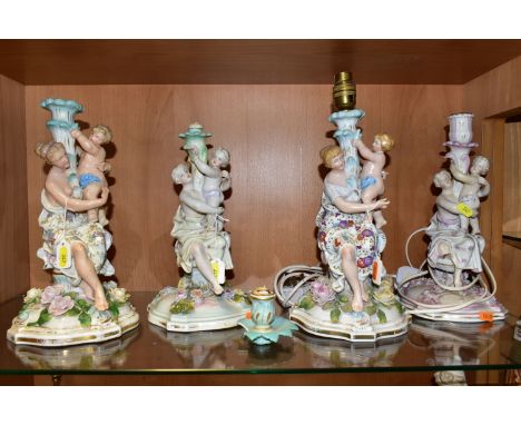 FOUR LATE 19TH CENTURY CONTINENTAL PORCELAIN FLORAL ENCRUSTED CANDLESTICKS, all modelled with a seated female figure with a p