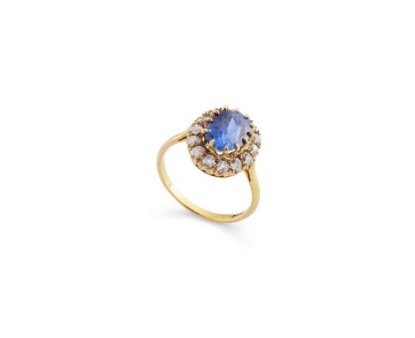  A Sri Lankan sapphire and diamond cluster ring  The oval-cut sapphire, within an old brilliant-cut diamond surround, diamond