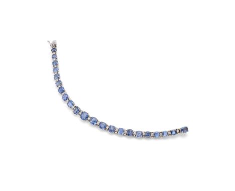  A sapphire and diamond line bracelet  The graduated row of cushion-shaped sapphires, the largest to the centre, spaced by ba