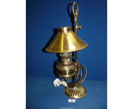 A brass electric lamp converted by Christopher Wray, with oil reservoir and ''coolie'' shape shade.