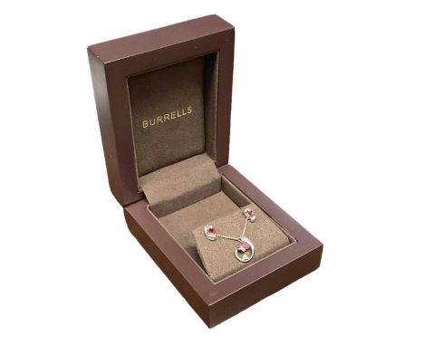 A suite of 9ct white gold ruby and diamond set jewellery, including a 9ct white gold necklace suspending a 9ct white gold pen