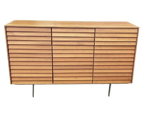 PUNT MOBLES; a mid century light oak veneered sideboard, with three drawers above three cupboard doors, raised on chrome supp