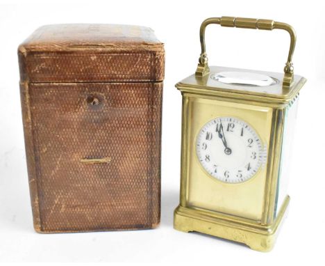 A 19th century French brass cased carriage clock with circular white enamel dial, height 12cm, width 9cm, with original leath
