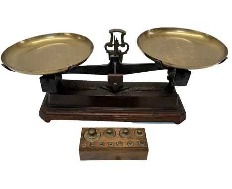 A pair of 19th century cast iron and brass Force 5 kilo balance scales with imperial weights in a block.