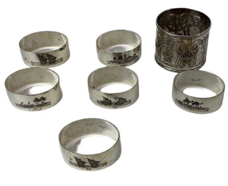 A set of six white metal napkin rings with engraved decoration of boats, landscapes and foliage, also a further white metal n