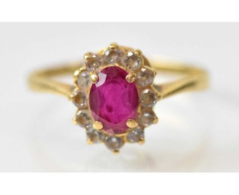 An 18ct yellow gold ruby and diamond set cluster ring, the central ruby approx 0.75ct, surrounded by twelve small diamonds, s
