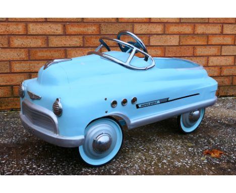 A children's pedal car in the manner of a 1950's 'Super Sport Comet'. The light blue car measures approximately 97cms in leng