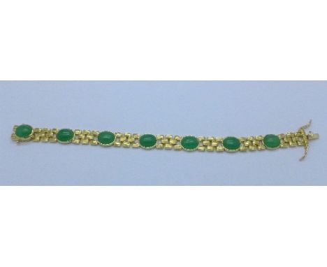 A silver gilt bracelet mounted with jade cabochons