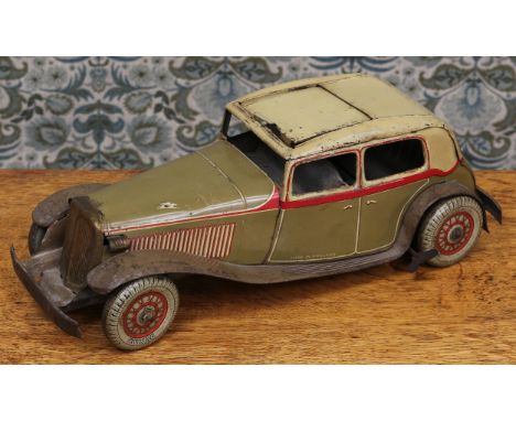 An early 20th century tinplate and clockwork saloon car, the lithographed tin body in olive drab with red detail, cream upper