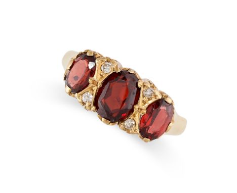 A GARNET AND DIAMOND DRESS RING in 18ct yellow gold, set with a trio of graduated oval cut garnets, accented by pairs of sing