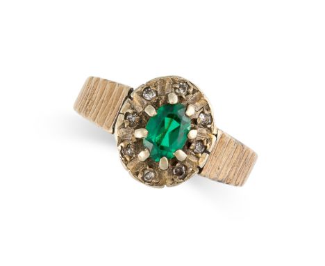 A VINTAGE PASTE GEMSTONE RING in 9ct yellow gold, set with an oval cut green gemstone in a cluster of white gemstones, Britis