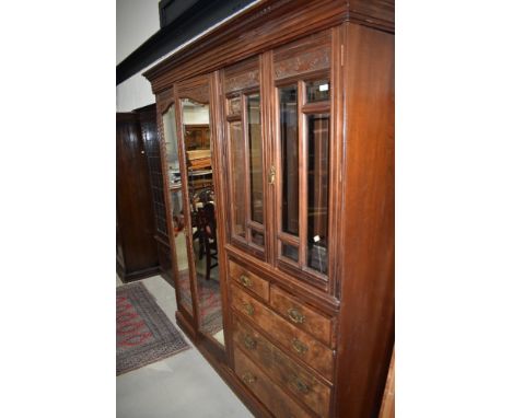 A late Victorian or Edwardian mahogany and walnut master robe of large proportions, comprising double mirror door section alo