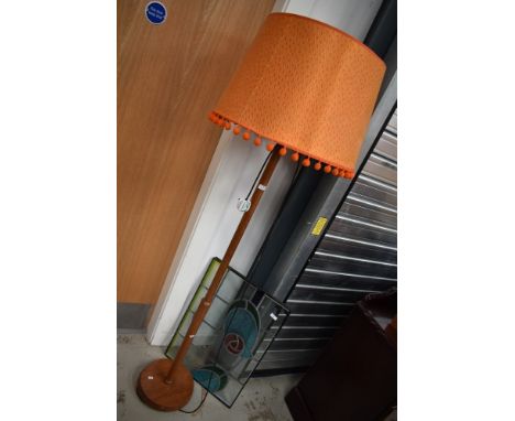 A vintage standard lamp with orange pom pom shade