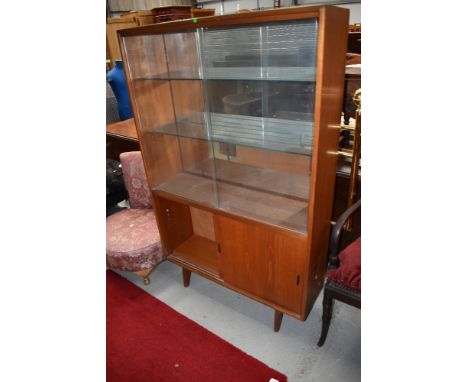 A vintage teak display cabinet having glazed upper section over cupboard, with sliding doors, labelled for Herbert Gibbs, wid