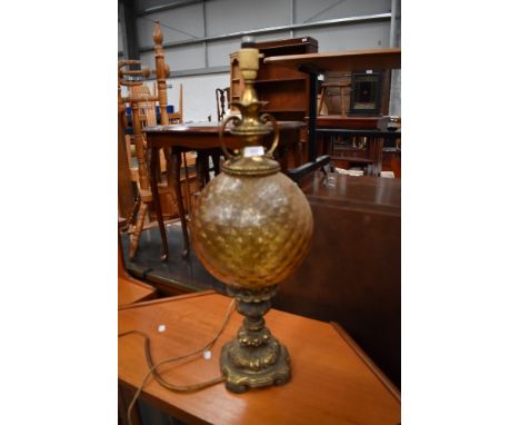 An antique ormolou lamp having detailed cast base with textured yellow glass balloon body