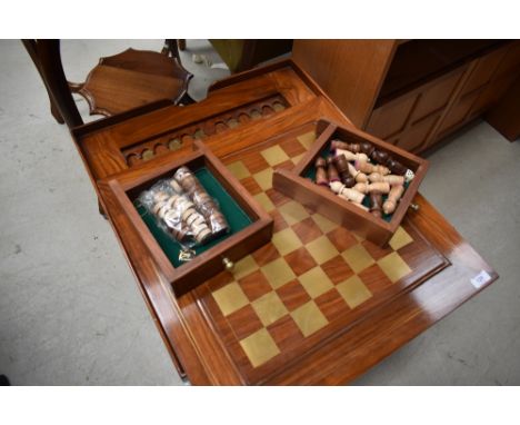 A modern hardwood occasional games table having brass inlay decoration, and reversible lid with chess board and concealed bac