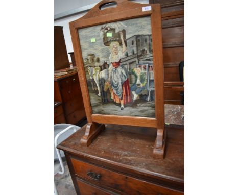 An early 20th Century firescreen having pictorial woolwork panel