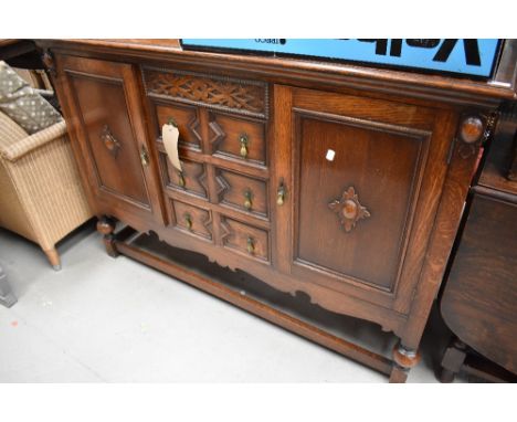 An early 20th Century oak sideboard having ledge back, three central drawers flanked by cupboard, width approx. 138cm, height