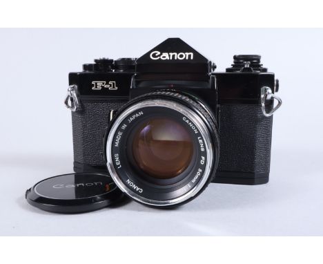 A Canon F 1n SLR Camera, black, serial no 596975, shutter working, meter responsive, self timer working. Body G-VG, some ligh