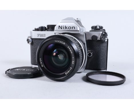 A Nikon FM2 SLR Camera, chrome, serial no 7206888, shutter working, meter responsive, self timer working, body G, light marks